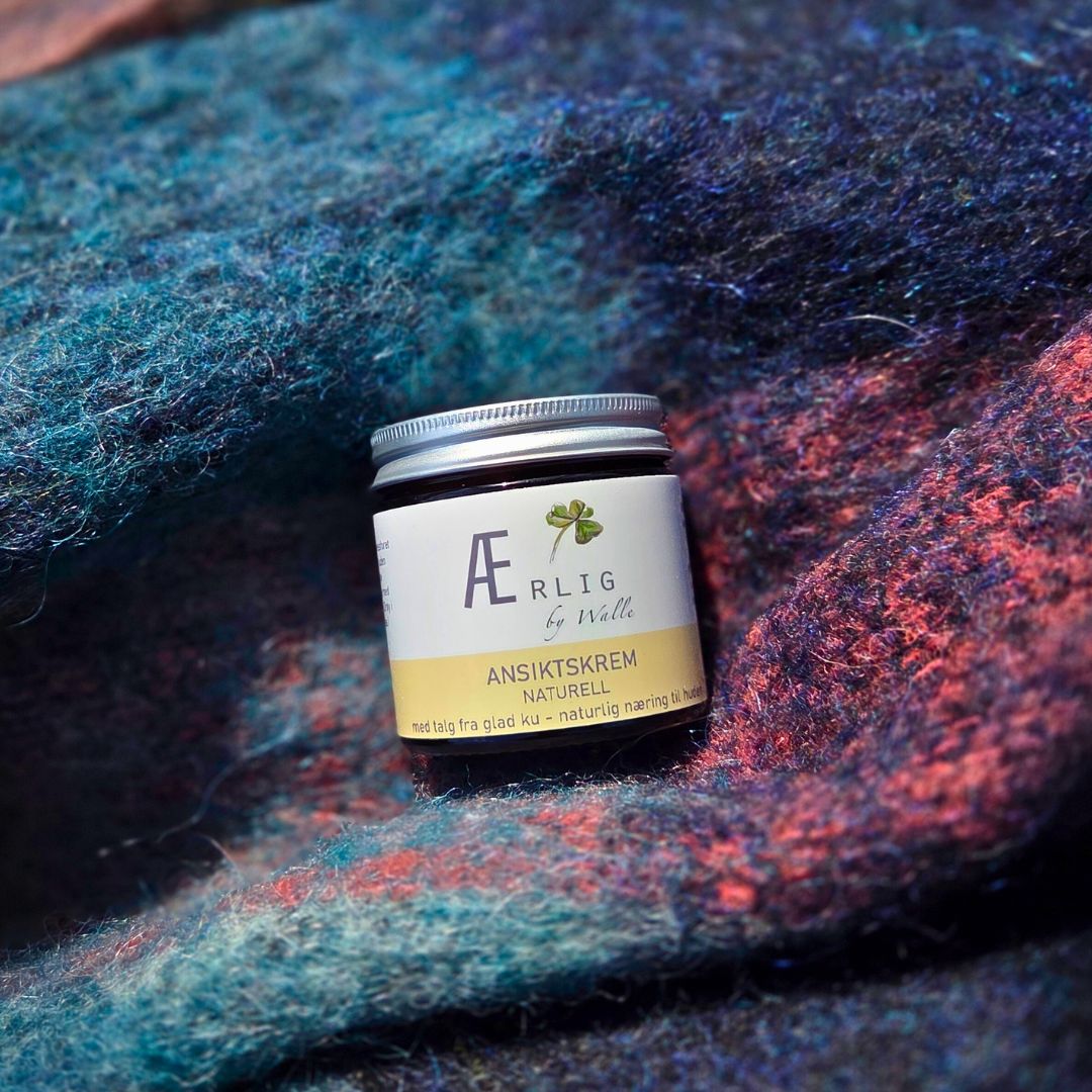 Glasskrukke med naturlig hudkrem fra Ærlig by Walle, plassert på fargerikt tekstil